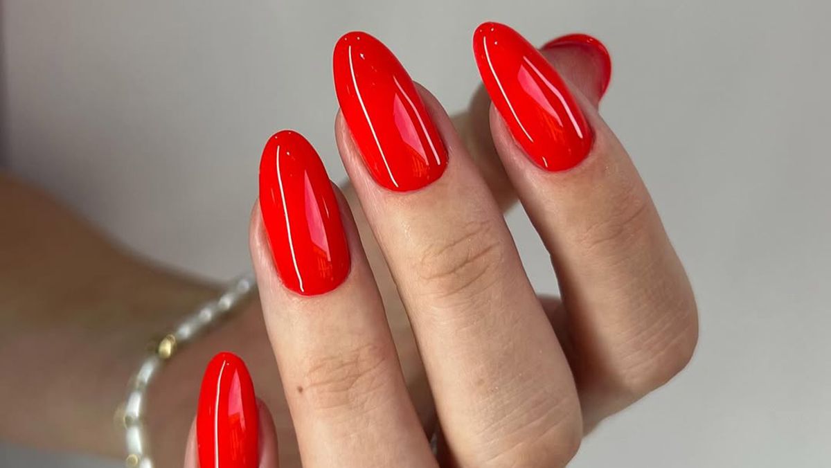 Красный маникюр является привлекательным Красный маникюр является привлекательным